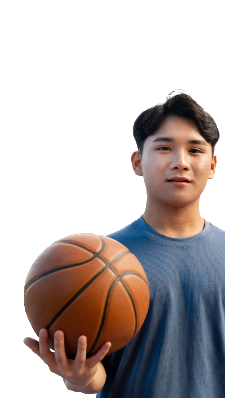 写真：バスケットボールを持つ青いTシャツを着た若いアジア人男性。真剣な表情で正面を向いている