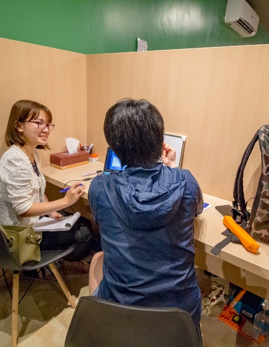 写真：個別指導エリアで、生徒と講師が対面でディスカッションをしている様子。集中できる環境が整っている。